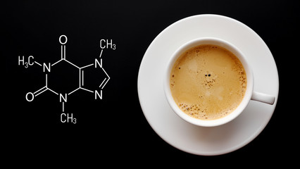 Cup of fresh coffee on a black background. Blackboard with the chemical formula of caffeine. Top view with copy space - obrazy, fototapety, plakaty
