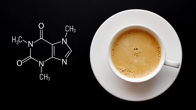 Cup of fresh coffee on a black background. Blackboard with the chemical formula of caffeine. Top view with copy space