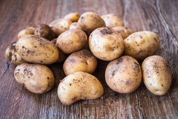 Young raw uncooked potato on table