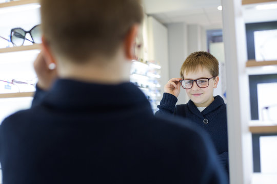 Cute young boy trying on glasses in an eyewear store