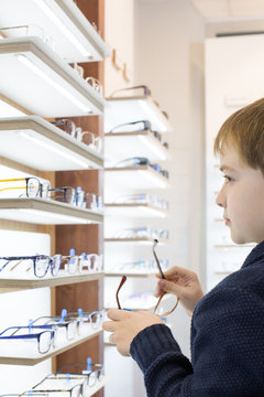 Cute young boy trying on glasses in an eyewear store
