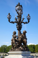 Fototapeta na wymiar Alexandre III bridge decorated street lamp with statues in Paris in a sunny summer day, France