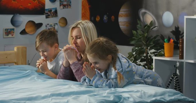 Mother and children praying together