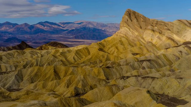 Golden Manly Beacon - Time-lapse video of panoramic morning view of Spring clouds passing over Manly Beacon and surrounding rolling hills. Zabriskie Point, Death Valley National Park, CA, USA.