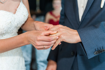 Obraz na płótnie Canvas bride put on the wedding ring on grooms finger
