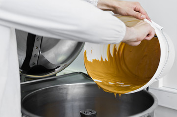 worker fills peanut butter in industrial mixer, food industry, conveyor line
