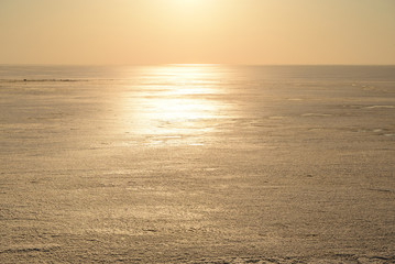 Frozen sea at sunny sunset.