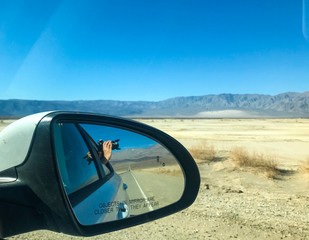 Death Valley, a photo depicting a photographer bouncing in a mirror taking pictures off a desert with digital camera