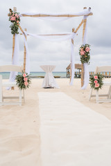 Dekoration einer Hochzeit mit Stuehlen am Strand mit Meer im HIntergrund