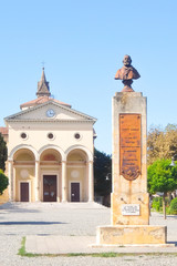 Fototapeta na wymiar Vada, Italy. View of Garibaldi square (piazza Garibaldi) and church of San Leopoldo (Chiesa di San Leopoldo) in small town Vada on the coast of the Ligurian Sea.