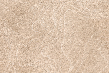 A top down shot of a dry river beige sand bottom full of texture and salt marks. Useful as abstract background.