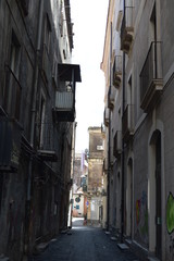 Narrow street in old town with graffiti, Sicily, Italy
