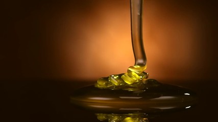 Honey pouring isolated on black background. Liquid Thick honey dripping over dark background, flowing syrup. Healthy food concept, diet, dieting. 4K UHD video slow motion 120 fps