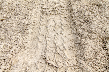 Footprints on the white sand from the car