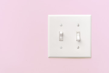 Interior light switch on pink wall with copy space.