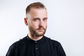 Fototapeta premium Headshot of blond serious young male blogger looks confidently at camera, over white background