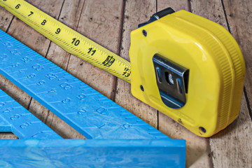 Locked tape measure on wooden table.