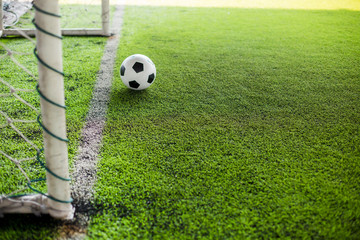 blurry soccer ball on green artificial turf move to goal at front of the goal line