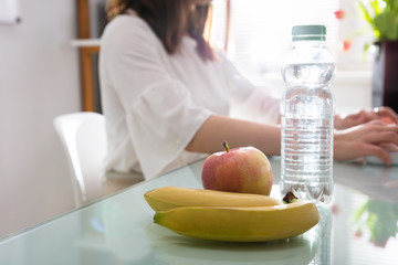 Apple, Banana And Water Bottle On Reflective Desk