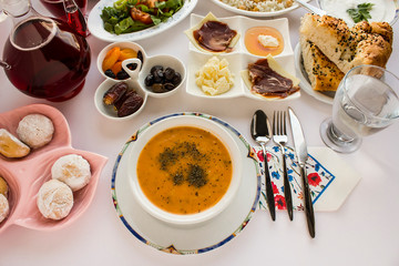 Soup is important element for Ramadan-iftar table.Traditional Turkish soup "Ezo gelin" on the Ramadan table with other symbolic foods.Top view.