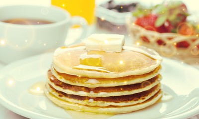 Stack of Small pancakes in syrup on background