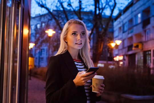 Young woman using smart phone outdoor in the evening