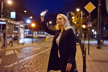 Young woman waiting for uber or taxi in the city