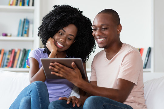 African american couple watching movie with tablet computer