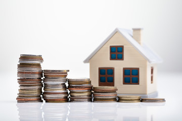 House Model Behind Stacked Coins