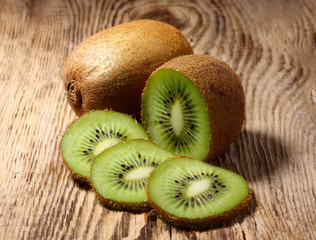 Kiwi fruit cut into pieces against a light background, close-up