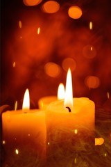 Candles light. Christmas candles burning at night. Abstract candles background. Golden light of candle flame.