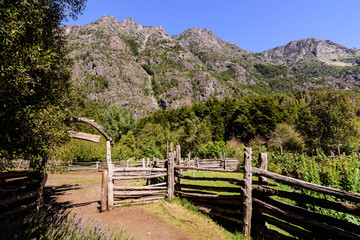 wooden fence on a farm against andes mountains