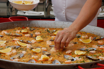 chef cooking spanish paella in outdoor area