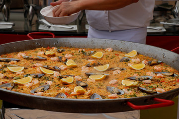 chef cooking spanish paella in outdoor area