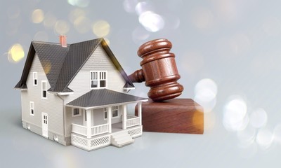 Wooden judge gavel and toy  house on  background