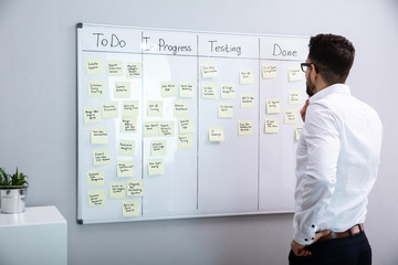 Businessman Looking At Adhesive Note On Board © Andrey Popov