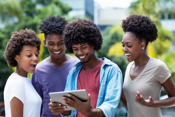 Group of african american young adults shopping online with digital tablet