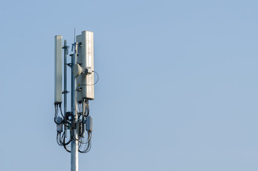 Telecommunication tower antenna on blue sky background.