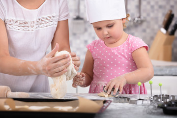 Cute Daughter Helping Her Mother To Make Cookies