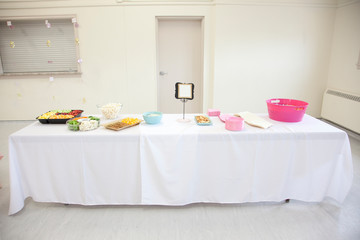 A table of snacks including fruit, veggies, dip and a blank sign