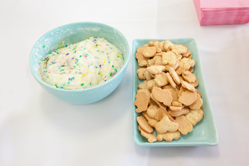 Sweet crackers or cookies with colorful icing dip on a party table