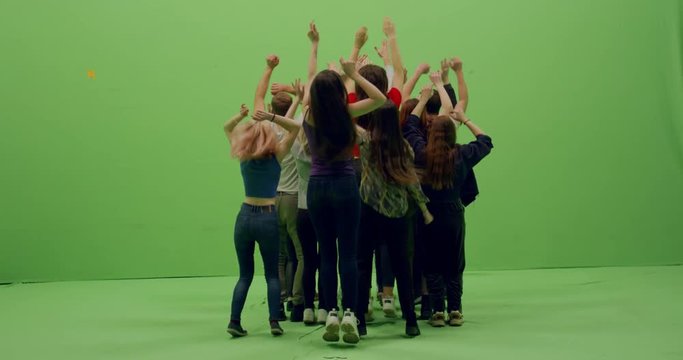 GREEN SCREEN CHROMA KEY Back view group of young people dancing and jumping with hands in the air. 4K UHD ProRes 4444