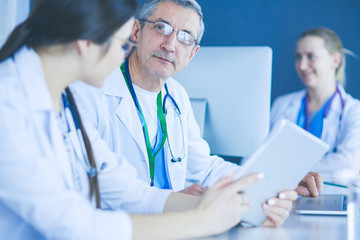 Fototapeta premium Serious medical team using a laptop in a bright office