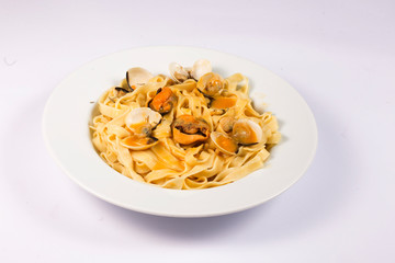 noodle dish with mussels and clams on white background