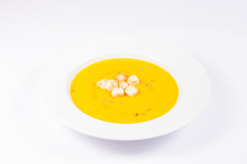 pumpkin cream dish with bread and oil on white background