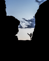Silhouette of female figure stretching at Arches National Park at sunset