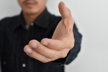 Close-up view of businessman hand reached out to handshake blurred in background.