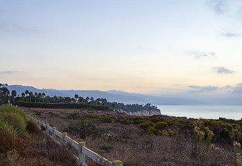 fence along cliff with ocean view with fog