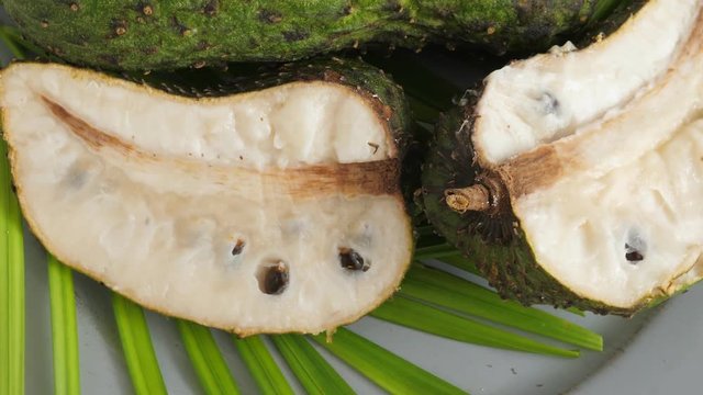 One soursop graviola, exotic, tropical fruit Guanabana on plate, Rotate
