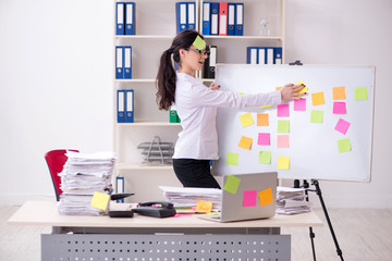 Young female employee in conflicting priorities concept 